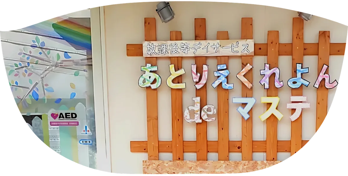 あとりえくれよんdeマステの看板。木の格子にマスキングテープの文字で施設名が貼られている