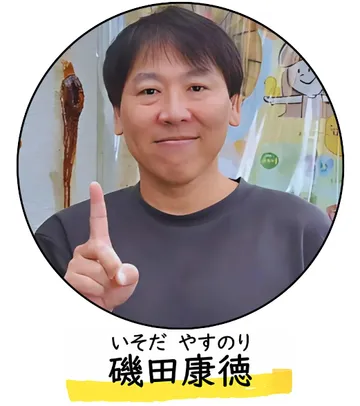人差し指を立てて、笑顔でこちらを見ている磯田先生